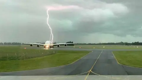 Momento en el que el rayo impacta cerca del avión de Emirates.