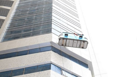Limpiadores de ventanas en un edificio de Emiratos Árabes. (Policía Ajman)
