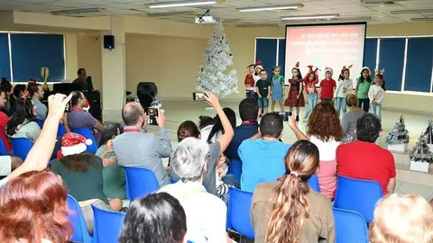 Las familias de los alumnos de 'El Cole' toman imágenes de la actuación de los niños durante el acto navideño celebrado por el centro en Dubai. (EL CORREO)