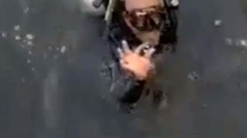 El buzo posa con el anillo recuperado.