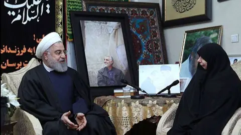 El presidente de Irán, Hasan Rohaní, con la viuda del comandante Soleimani, ante una foto de este, este sábado en Teherán. (Reuters)