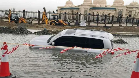 Un coche atrapado en el agua como consecuencia del temporal en el emirato de Sharjah. (EL CORREO)