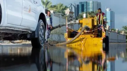 Trabajadores de Dubai drenan el agua de lluvia. (Dubai Media Office)