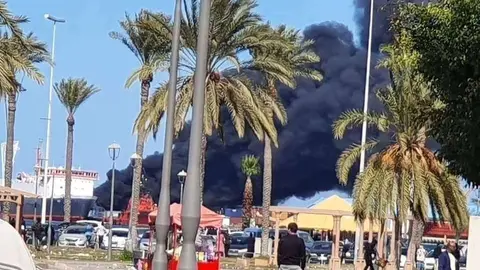Humo desde un barco en el puerto de Trípoli. (Al Arabiya)
