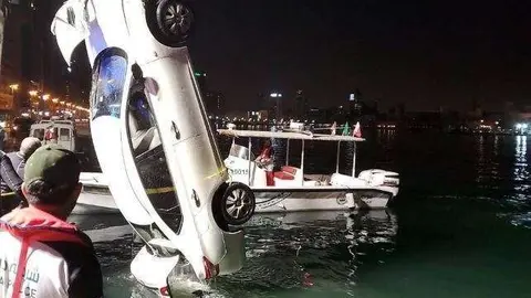 Una grúa saca el coche del Creek de Dubai.