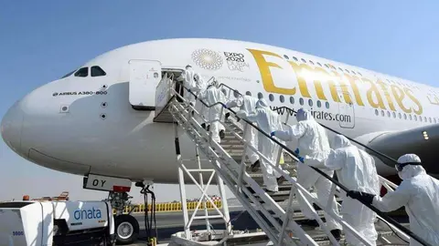 Personal de limpieza accede a un avión de Emirates.