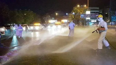 Una imagen de The National de empleados desinfectando una calle.