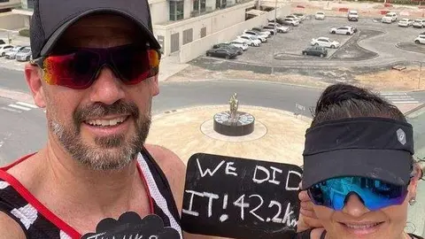 Los dos expatriados en su balcón de Dubai tras completar el maratón. (Twitter)