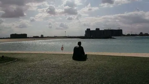 Un hombre descansa en una playa de Emiratos Árabes. (EL CORREO)