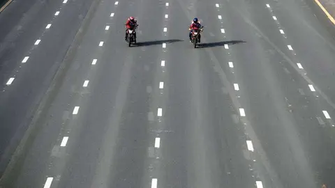 Dos repartidores en una calle vacía de Dubai. (EPA)