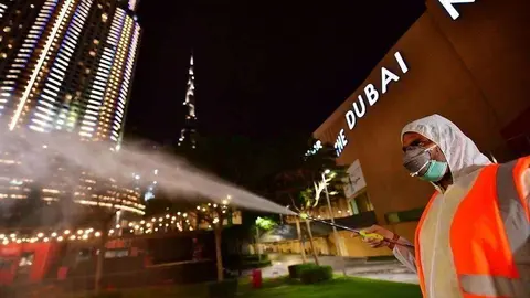 Un trabajador desinfecta una calle de Dubai. (Al Arabiya)
