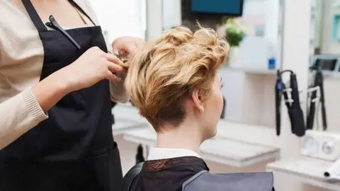 Una mujer se arregla el cabello.