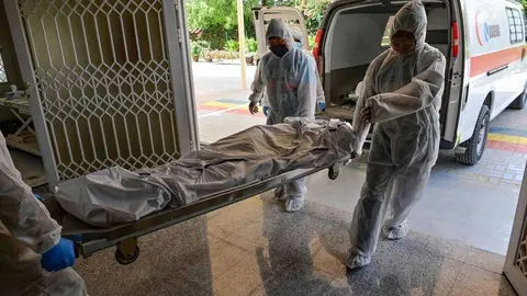  Empleados transportan el cuerpo de una víctima de Covid-19 para ser incinerado en el crematorio hindú New Sonapur en Dubai el 19 de abril de 2020. (AFP)