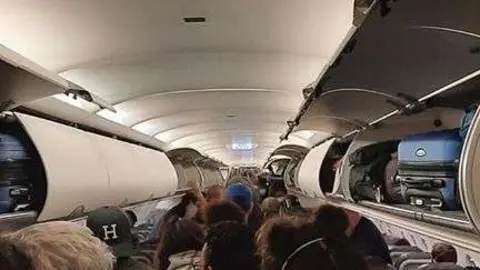 Gonzalo Rus muestra el pasillo del avión de Iberia en el que viajó a Madrid.