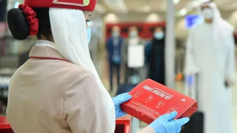 Empleada de Emirates con un set higiénico en el aeropuerto de Dubai. (Twitter)