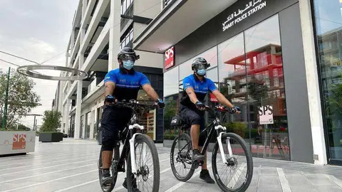 Policías de Dubai en bicicleta con cascos inteligentes y mascarillas. (WAM)