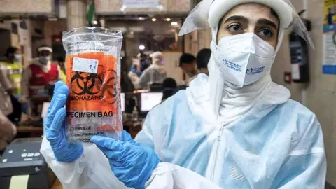 Un trabajador de la salud en EAU recolecta muestras. (The National)