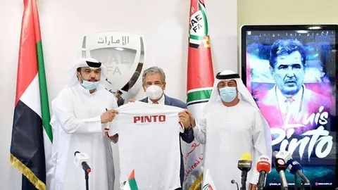 Jorge Luis Pinto muestra la camiseta de la Selección de Emiratos junto a directivos del equipo. (Cedida)