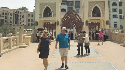 Turistas en el puente que da acceso a Souk Al Bahar en la plaza de Fuente de Dubai. (EL CORREO)