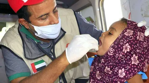 Personal de la Media Luna Roja de Emiratos atiende a una niña en la costa del Mar Rojo de Yemen. (WAM)