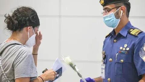 Mujer libanesa, emocionada ante la rosa blanca que le entrega Dubai. (WAM)