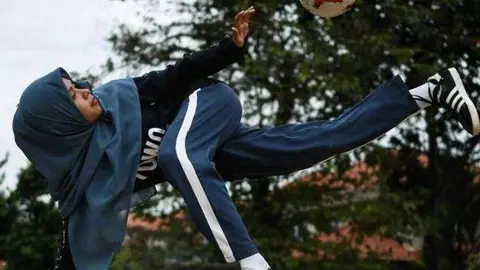 Una mujer árabe juega al fútbol.