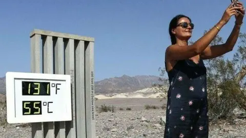 Una visitante frente a un termómetro no oficial en el Parque Nacional Death Valley en California. (Twitter)