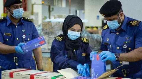 Funcionarios emiratíes manipulan equipo sanitario en la lucha contra el coronavirus. (WAM)