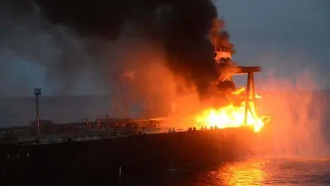 En la imagen de Reuters, el petrolero en llamas.