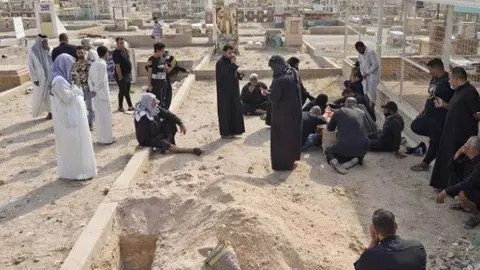 En la imagen de AFP, los iraquíes desenterrando cadáveres.