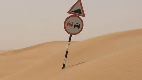 Señal de tráfico enterrada en arena en la carretera de Liwa a Tal Moreb. (EL CORREO)