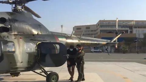 El senderista reciba ayuda para subir al helicóptero. (Policía RAK)