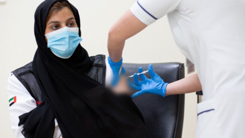 Una emiratí recibe una dosis de la vacuna Covid. (WAM)