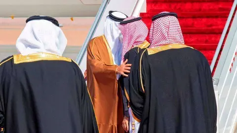 El príncipe heredero saudí da la bienvenida al emir de Qatar con un abrazo. (AFP)