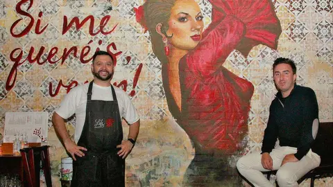Daniel Pérez Delgado, chef de 'Lola' -izquierda-, Lloy Rubio, director general de la taberna española, junto al impresionante mural de Lola Flores que preside el 'Jamón Bar' de establecimiento. (EL CORREO)