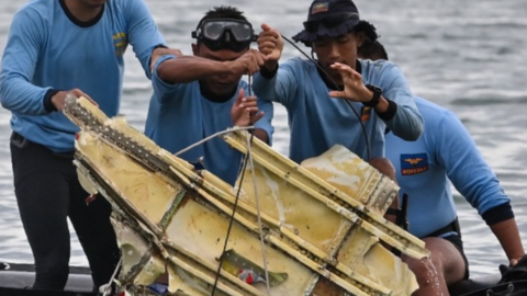Rescatistas encuentran en el mar partes del avión. (AFP)