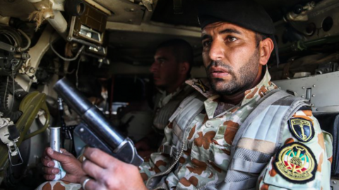 Un militar iraní dentro de un transporte de tropas y sosteniendo un lanzador de bengalas (Ejército Irán)