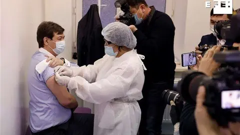 El médico sanitario jefe de Kazajistán, Yerlan Kiyasov (izquierda), recibe la primera dosis de la vacuna rusa Sputnik V contra el coronavirus en Nur-Sultán, Kazajistán, este lunes. (Efe)