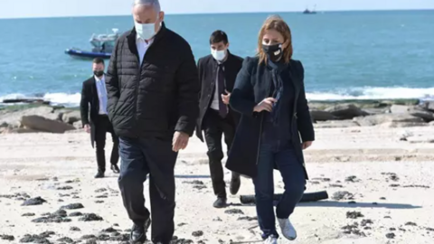 El primer ministro de Israel, Benjamin Netanyahu, y la ministra de Protección Medioambiental, Gila Gamliel, pasean por una playa afectada por los vertidos de petróleo.