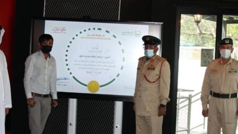 La Policía de Dubai difundió esta imagen del conductor honrado junto a unos oficiales.