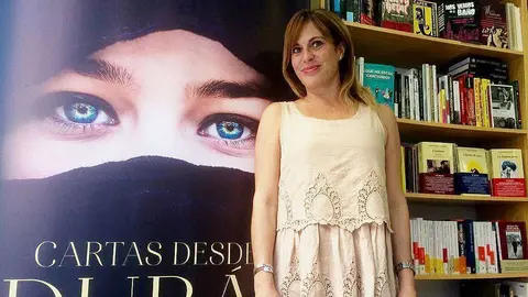 Asunta López, junto a una gran portada de su exitosa novela, 'Cartas desde Dubai'. (Cedida)