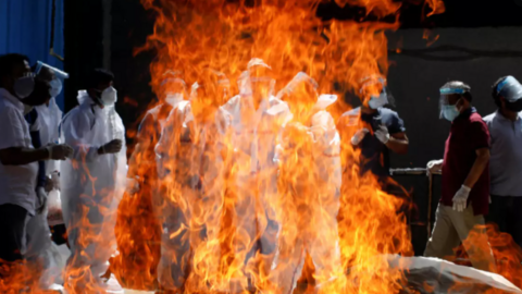 Personas con equipo de protección velan a un ser querido que falleció por Covid-19 en un crematorio en Nueva Delhi, India, el 21 de abril de 2021. (Reuters)