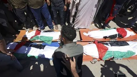 Palestinos participan en el funeral de la familia Abu Hatab en la ciudad de Gaza el 15 de mayo de 2021. (AFP)