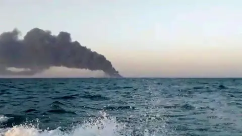 Esta imagen tomada de un vídeo publicado el miércoles 2 de junio de 2021 por Asriran.com, muestra humo que se eleva desde el barco de apoyo de la armada de Irán Kharg en el Golfo de Omán. 