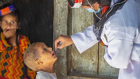 Un niño muy atento a lo que ocure recibe la dosis durante la campaña contra la polio impulsada por Emiratos Árabes en Pakistán. (WAM)