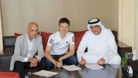 El joven ciclista en el centro de la imagen durante la firma del contrato. (WAM)