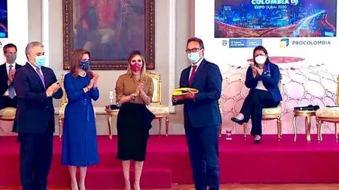 El presidente Iván Duque entrega al comisionario de la Expo 2020 Dubai Juan Cavelier la bandera que presidirá el pabellón de Colombia. (Twitter)