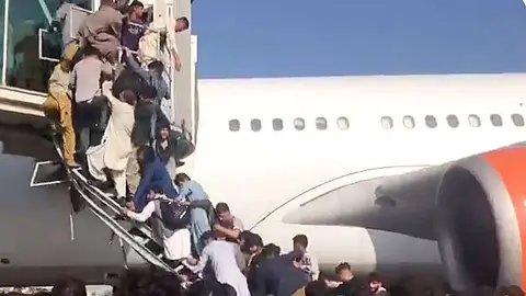 Decenas de personas asaltan el acceso de un avión en el aeropuerto de Kabul. (@NicolaCareem)