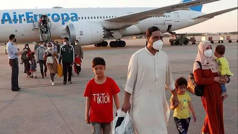 En la imagen de Efe, los evacuados en el segundo vuelo fletado por España procedente de Afganistán descienden del avión en Madrid. 