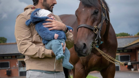 El jeque Hamdan con su hijo en brazos y el caballo campeón. (Twitter)